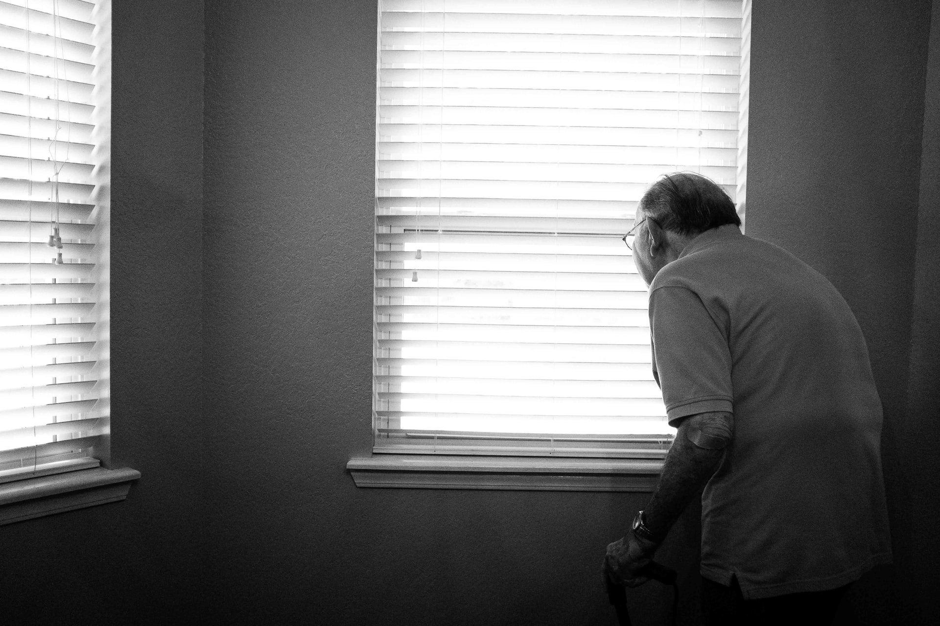 An elderly man looking out his window, representing the impact on COVID on nursing homes