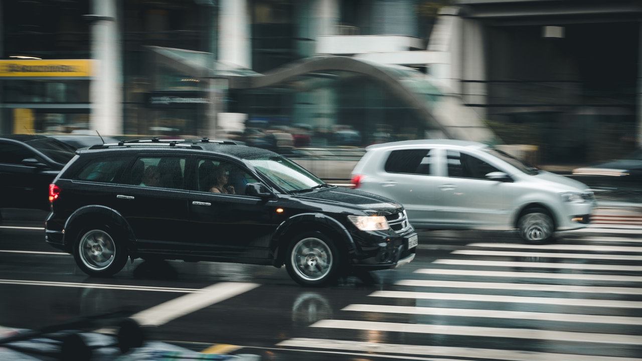 Cars on a city street representing insured drivers and what might change in Alberta if no-fault insurance is adopted