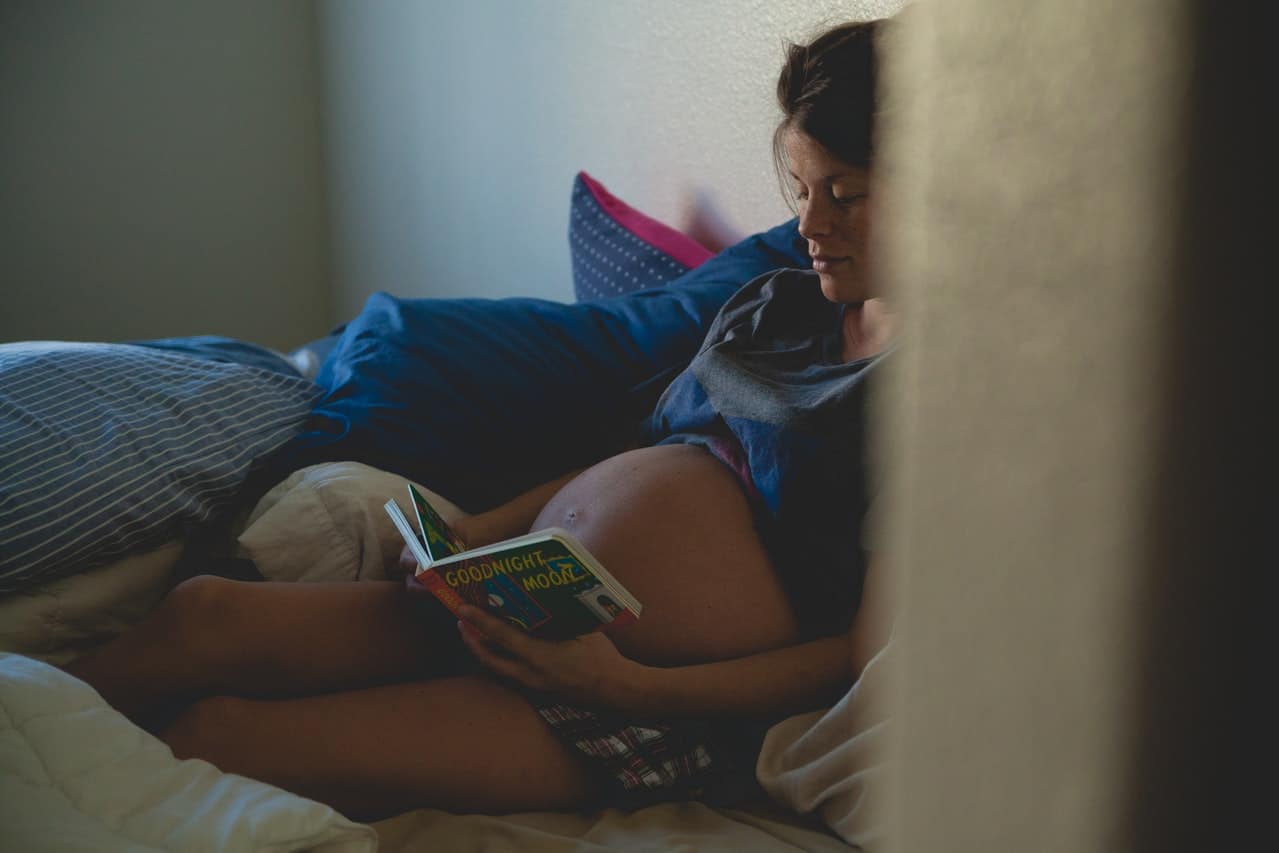 a pregnant woman reading a book