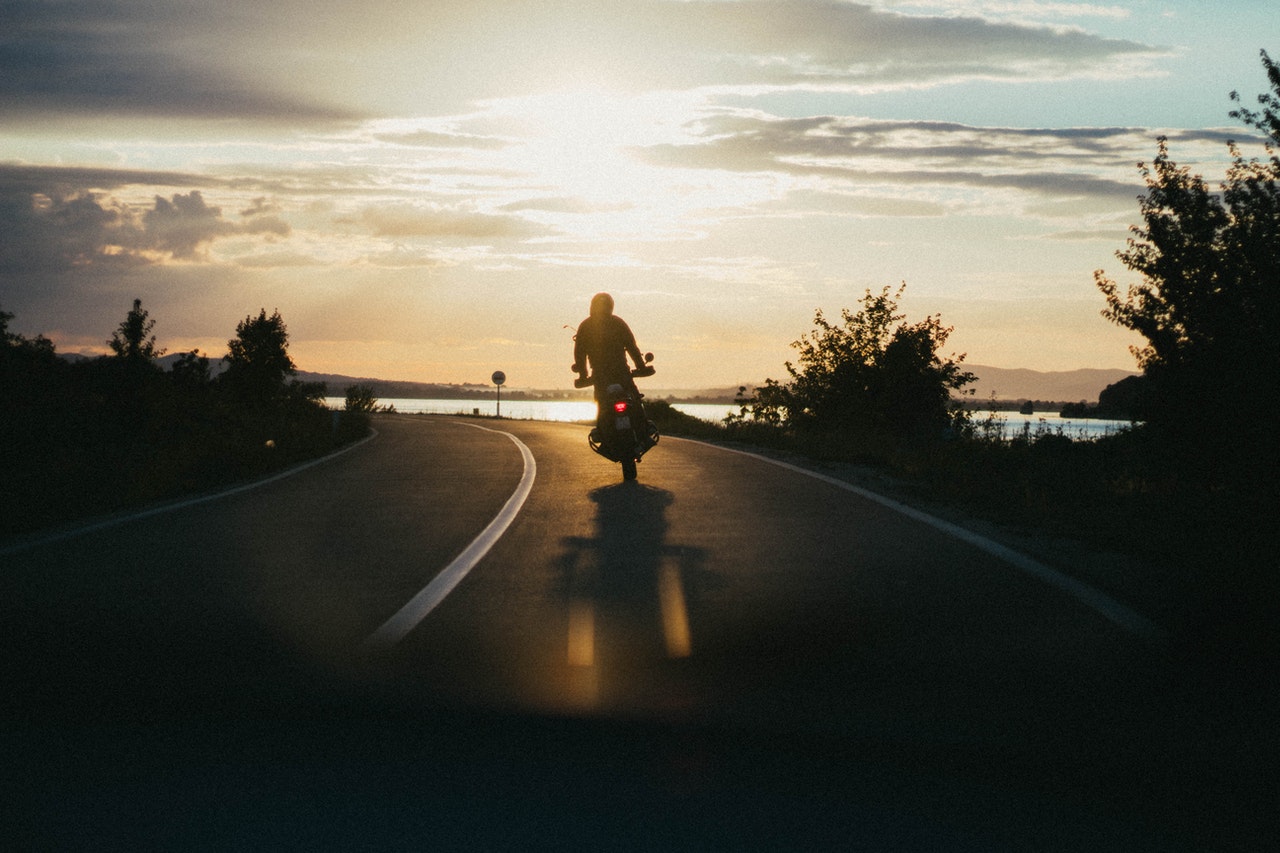 motorcyclist on highway at sunset