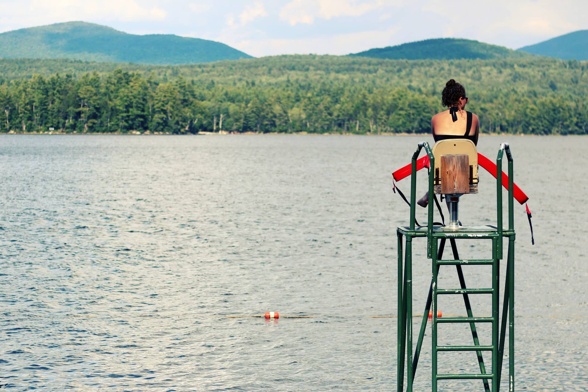 Lifeguard on tower overlooking a lake, representing drowning prevention and water safety