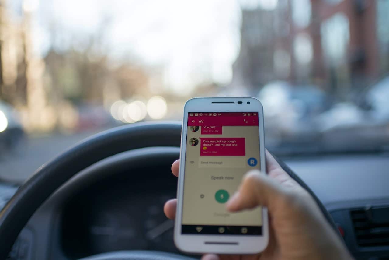 person holding smartphone while driving