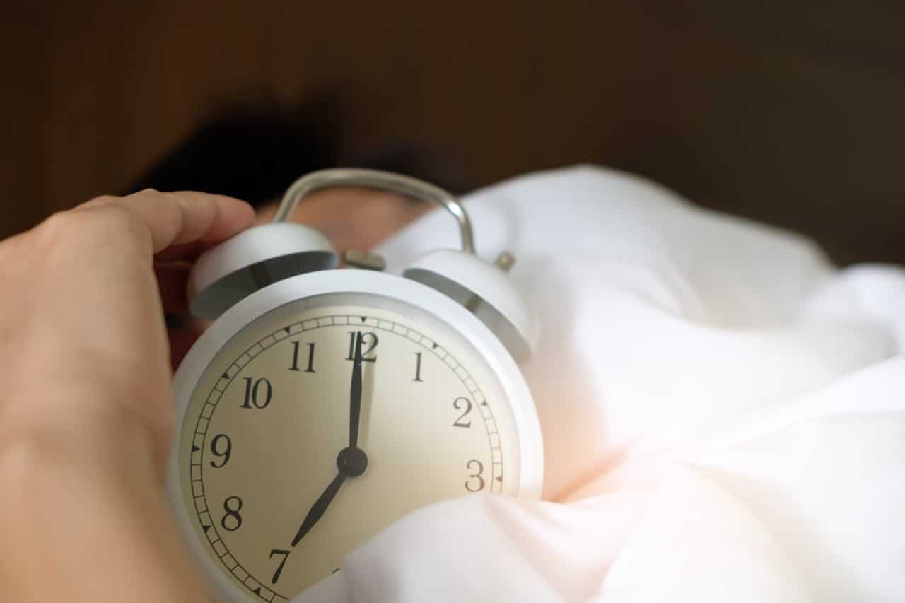 a photo of a person holding an alarm clock