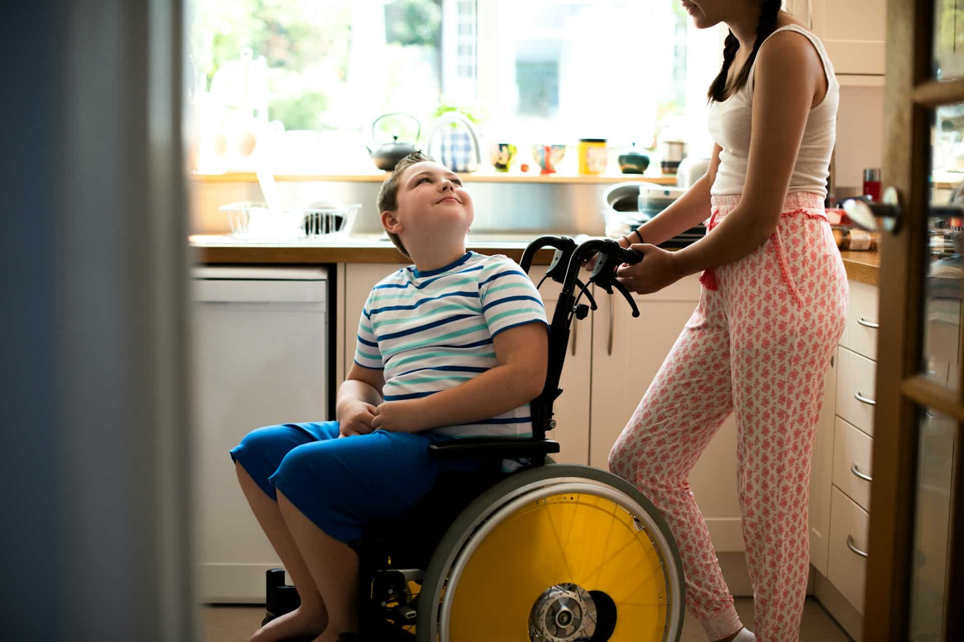 a person helping a disabled young boy