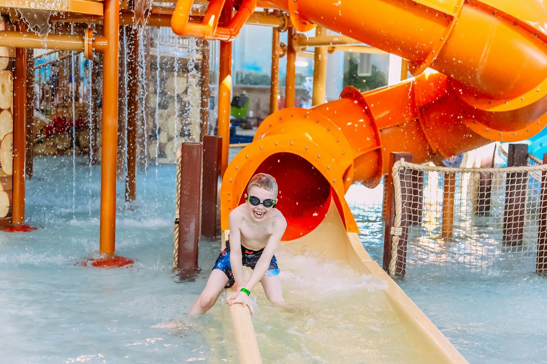 A boy playing at the bottom of a waterslide, representing water park injuries.