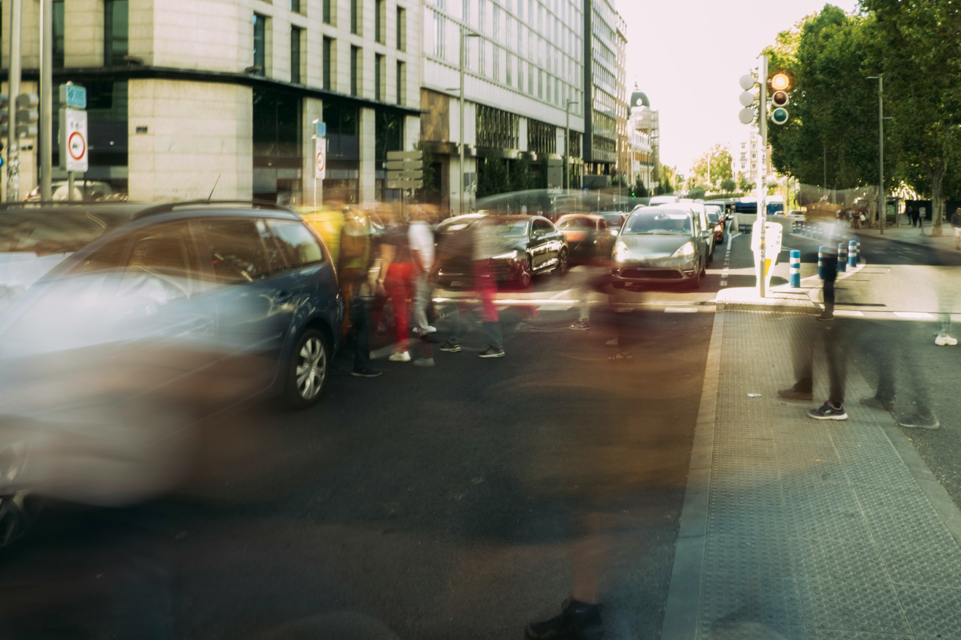 Blurred pedestrians walk between cars on a busy city street, representing fatal traffic accidents in Alberta.