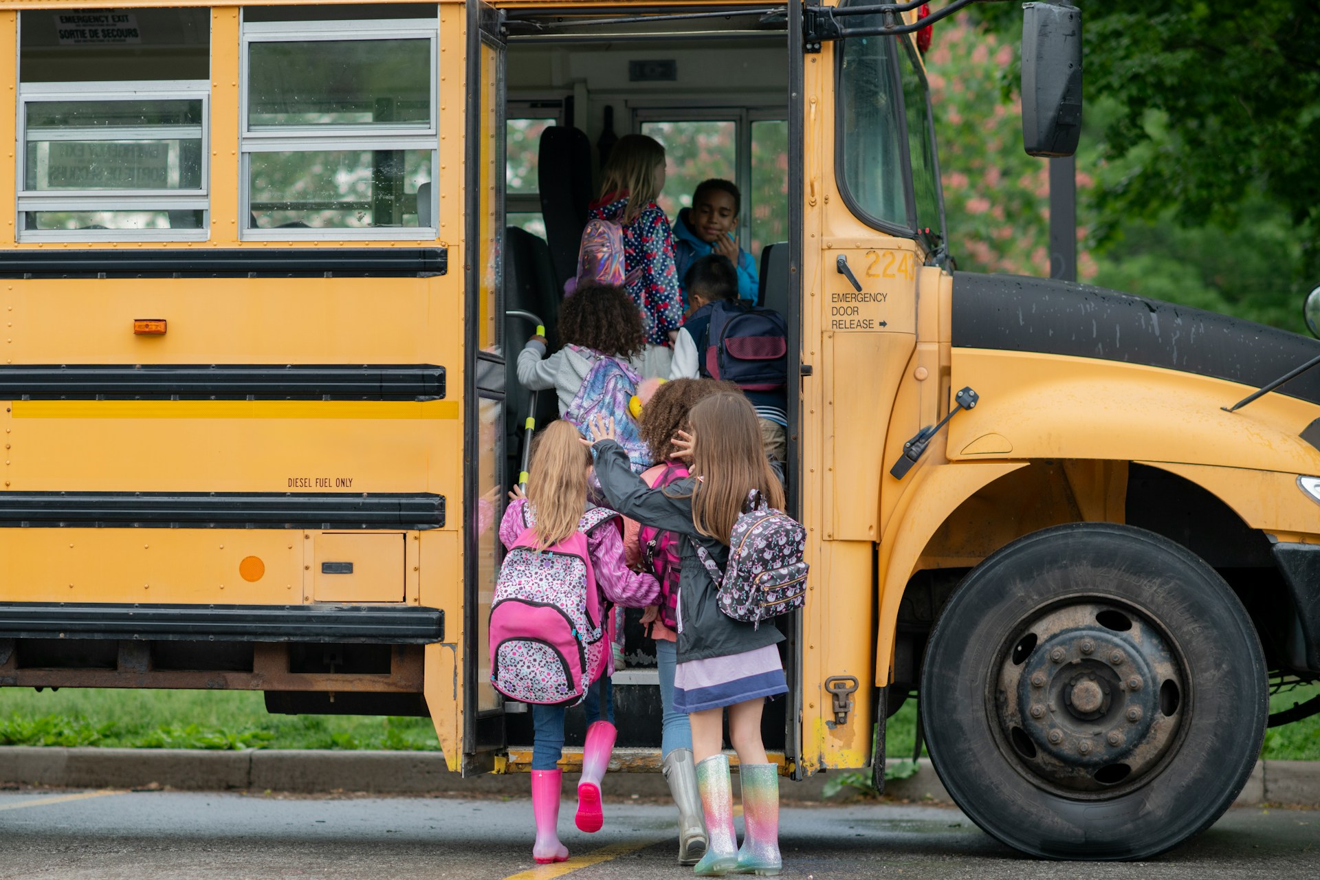 Children boarding a yellow school bus, representing school bus accidents when a driver fails to stop.